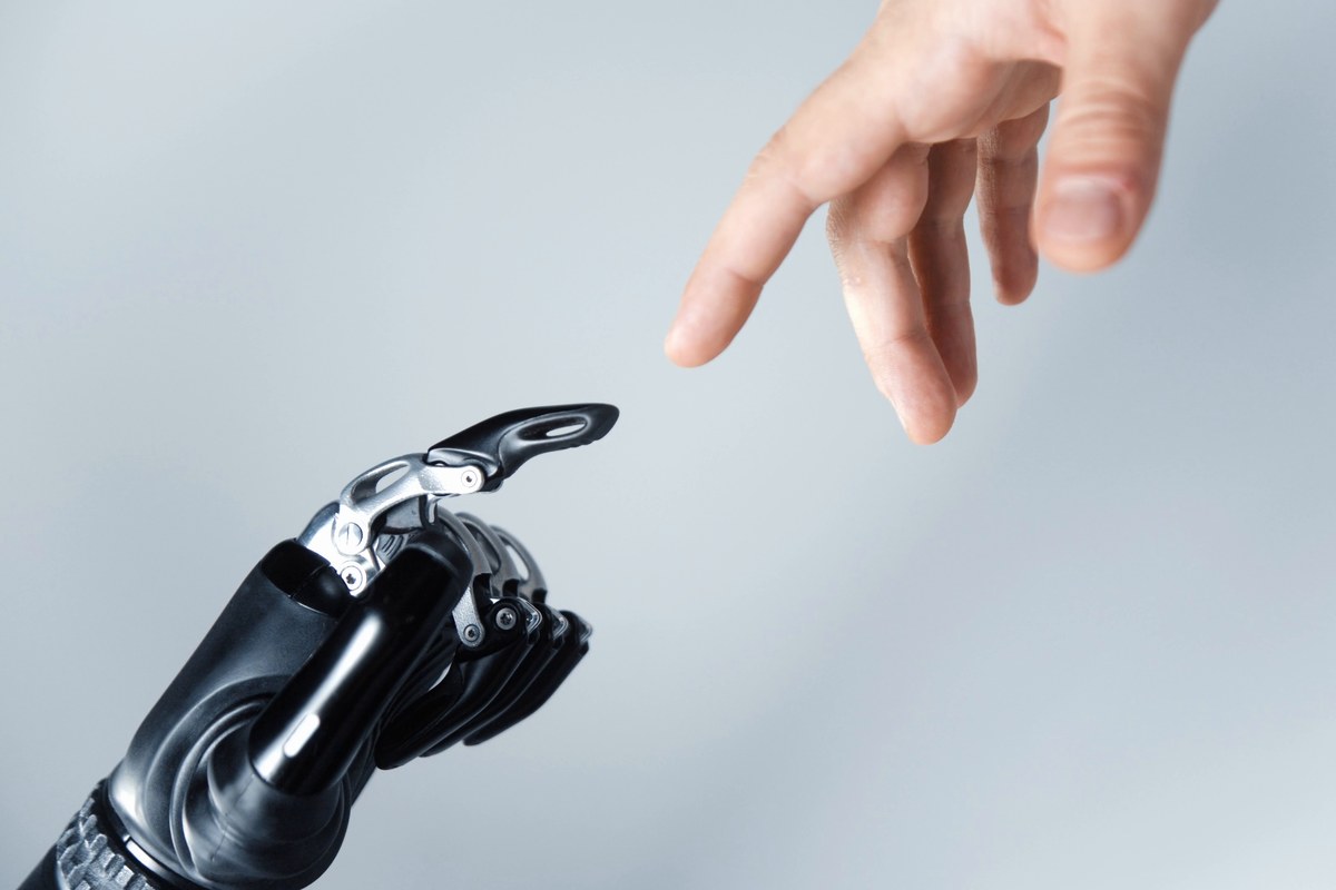 A human hand and a robotic hand reaching toward each other